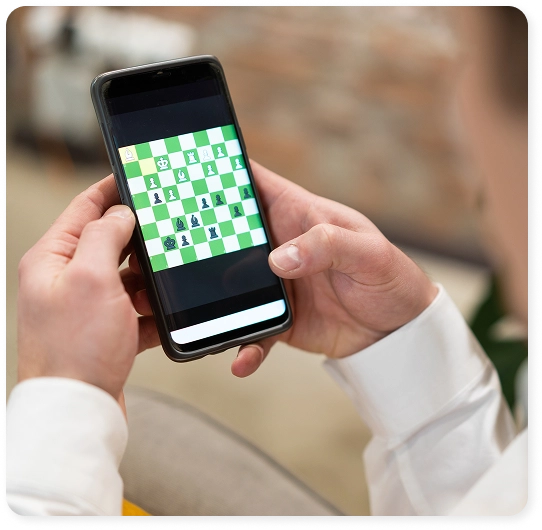 Een man speelt thuis schaak op zijn laptop, in een gezellige omgeving met de schaakstukken naast zich